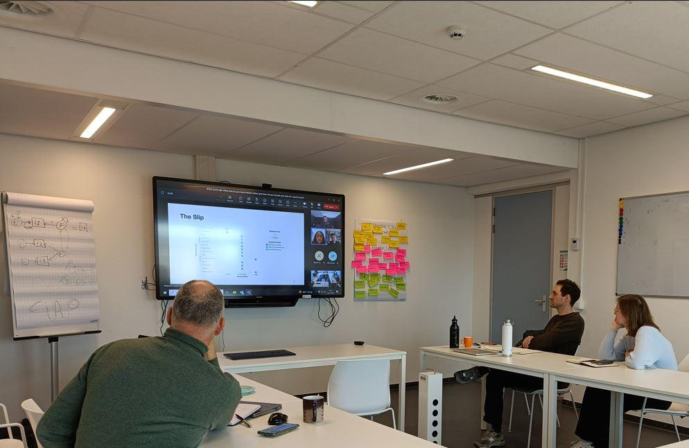 Three people following an online presentation about the dataslip machine