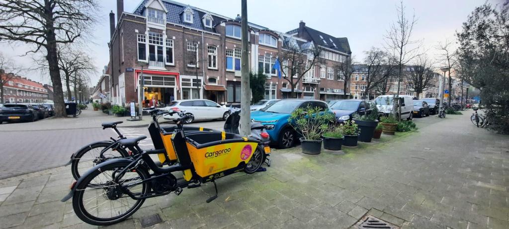 A picture of a street in Amsterdam. In the front, two electrical, shareable bikes are parked