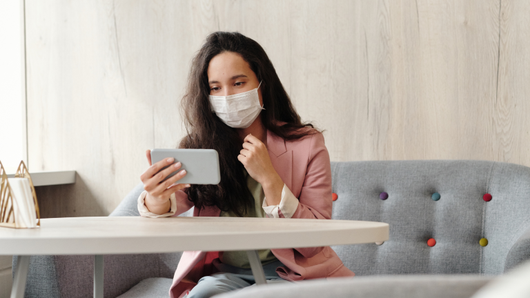 Woman wearing a mask and holding a phone